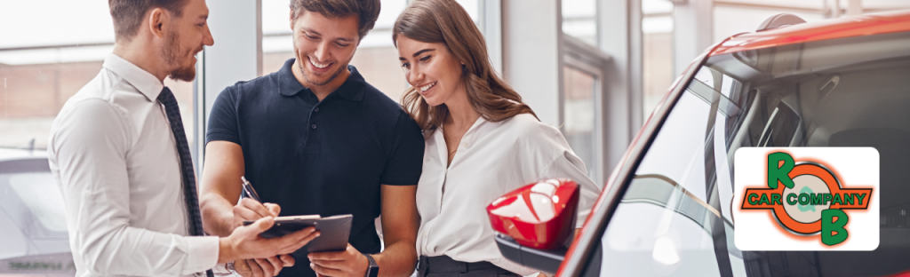 Used car lineup displayed at R&B Car Company, Warsaw auto trader, with local pricing signs